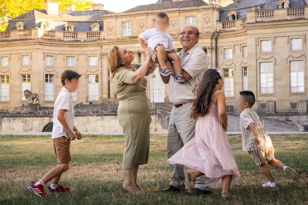Großeltern tanzen und spielen bei Familienfotoshooting mit ihren Enkeln