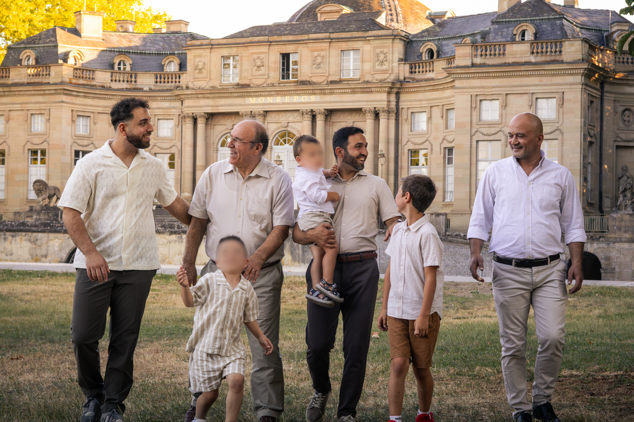 Die Männer aus drei Generationen einer Familie laufen und unterhalten sich vor dem Schloss Monrepos