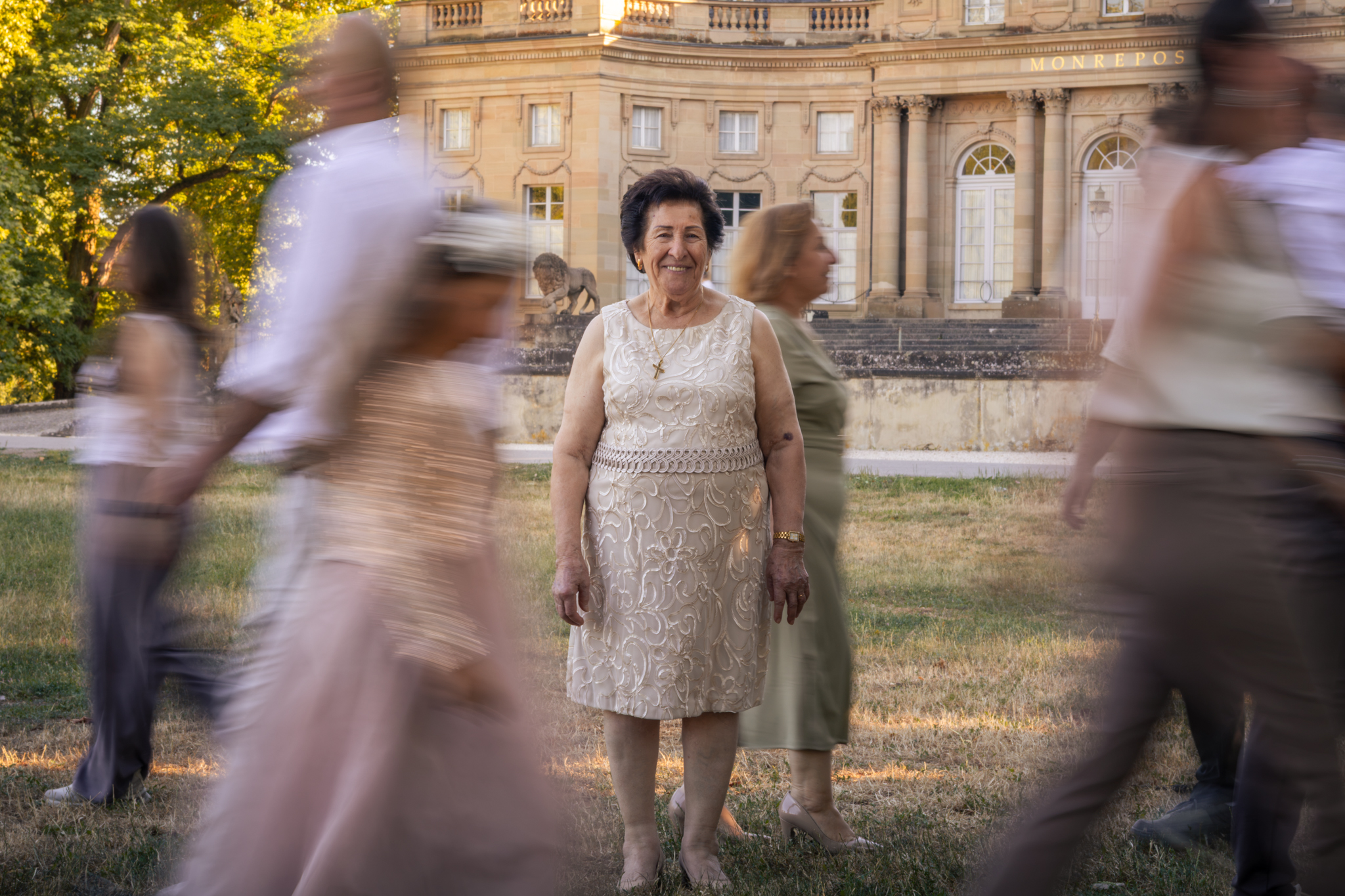 Künstlerische Aufnahme einer Seniorin, deren Kinder, Enkel und Urenkel an ihr vorbeispazieren